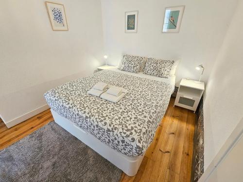 um pequeno quarto com uma cama e piso em madeira em Stay at Home in Lisbon em Lisboa