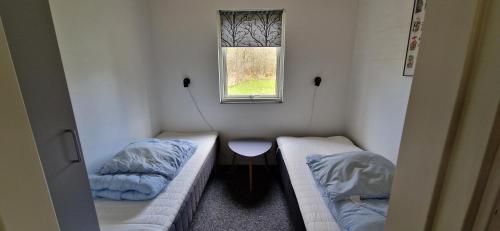 a small room with two beds and a window at Brinken at Ry in Ry