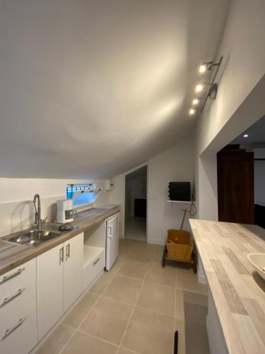 a kitchen with white cabinets and a counter top at Maisonnette, accès direct plage, entre Cannes & Antibes in Vallauris