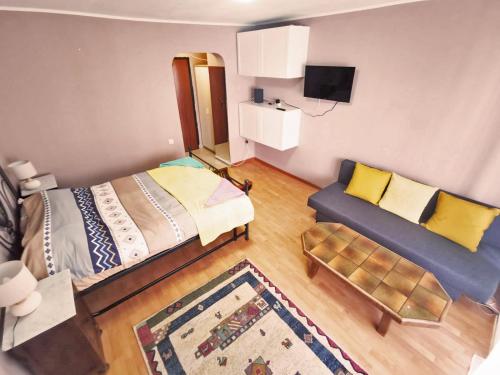 a small bedroom with a bed and a couch at Cozy Studio Athenee in Bucharest