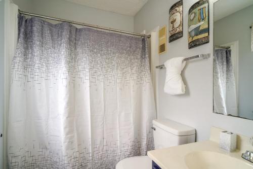 La salle de bains est pourvue d'un rideau de douche et de toilettes. dans l'établissement Lovely Gatlinburg Condo Pool, Less Than 2 Mi to Tramway!, à Gatlinburg