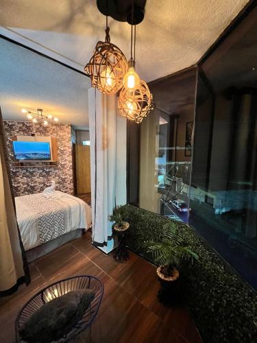 a bedroom with a bed and a chandelier at Habitación Deluxe con Balcón in Orizaba