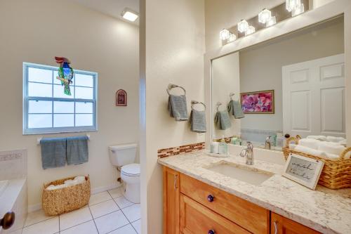 a bathroom with a sink and a toilet and a mirror at Tarpon Springs Family Getaway with Patio and Hot Tub! in Tarpon Springs