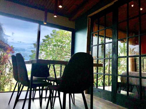 a dining room with chairs and a table and a window at El Refugio La Brisa del Diablo in Valle Hornito