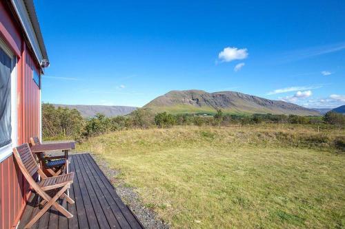 a wooden deck with a bench on the side of a house at Sólvellir Holiday Home in Kjósahreppur