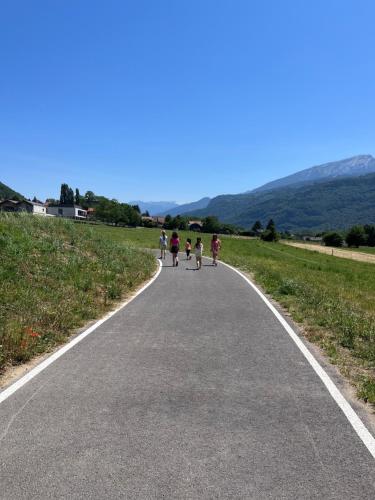 a group of people walking down a road at Entre vignes et montagnes in Ayse
