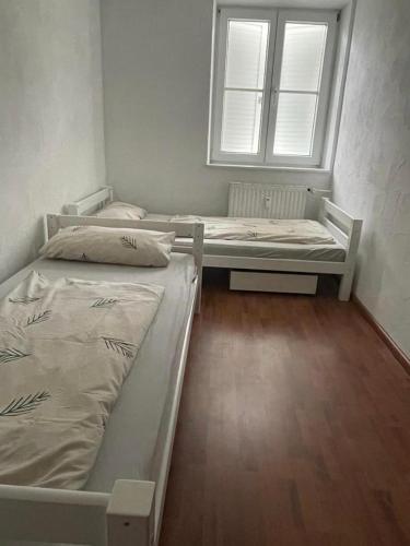 dwa łóżka w pokoju z oknem w obiekcie Apartment Lara w mieście Friedrichshafen
