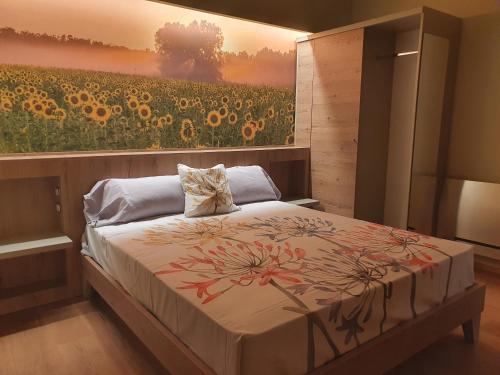 a bedroom with a painting of a field of sunflowers at Le stagioni della vita in Bovino