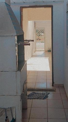 une porte ouverte menant à une chambre revêtue de carrelage. dans l'établissement Casa da Taty, à Tatuí
