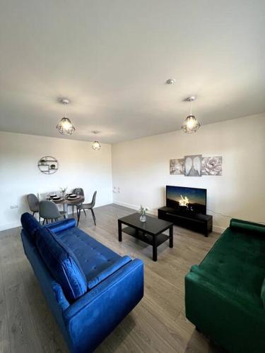 uma sala de estar com um sofá azul e uma lareira em Spacious One Bedroom Apartment em Hemel Hempstead
