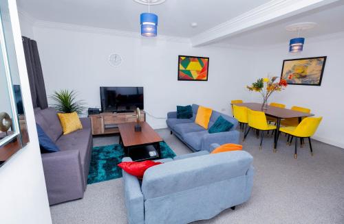 a living room with a blue couch and a table at Wandle Grove House in Birmingham