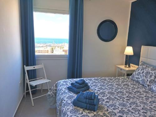 a bedroom with a bed with blue towels on it at Appartement standing Vue panoramique OceanSight Beach 250m in Los Cristianos