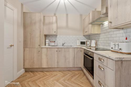 a kitchen with wooden cabinets and a microwave at Luxury Apartment - Roe Getaway Limavady in Limavady