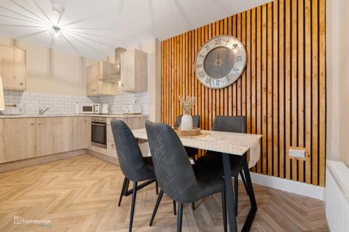 a kitchen with a table and chairs and a clock on the wall at Luxury Apartment - Roe Getaway Limavady in Limavady