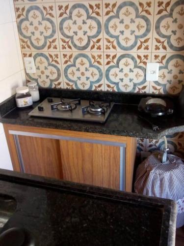 um balcão de cozinha com um fogão e uma parede em Espaço Alternativo - a sua casa em Carmo do Rio Claro em Carmo do Rio Claro