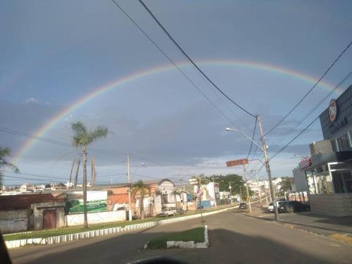 um arco-íris no céu sobre uma rua da cidade em Espaço Alternativo - a sua casa em Carmo do Rio Claro em Carmo do Rio Claro