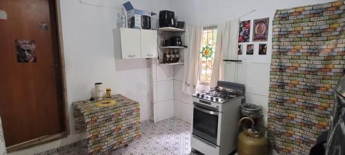 a small kitchen with a stove and a window at Casa da Luz stl Hostel in São Thomé das Letras