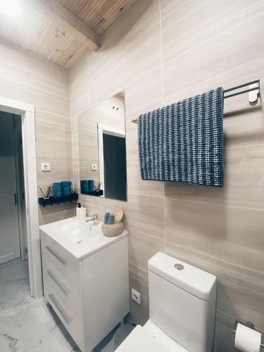 y baño con aseo blanco y lavamanos. en Apartamento KENOA metropolitano, en Madrid