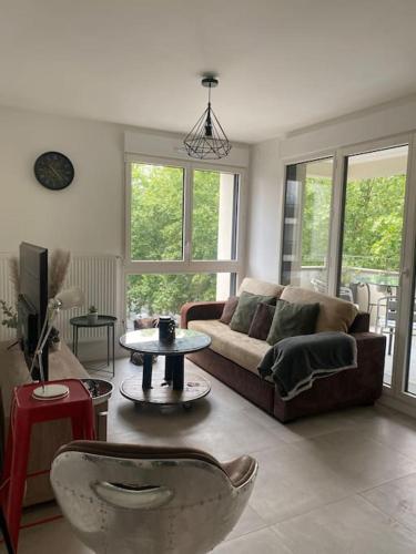sala de estar con sofá y mesa en T3 cosy et lumineux avec terrasse en Noisy-le-Sec