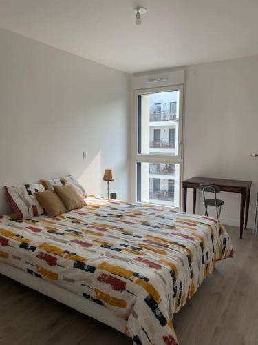 une chambre avec un grand lit et un bureau dans l'établissement T3 cosy et lumineux avec terrasse, à Noisy-le-Sec