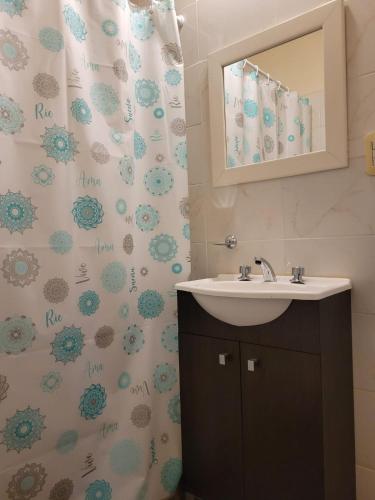 a bathroom with a sink and a shower curtain at Jucaso Departamentos in San Pedro