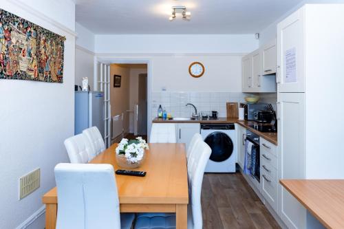 a kitchen with a wooden table and white appliances at Raven Haven Glastonbury in Glastonbury