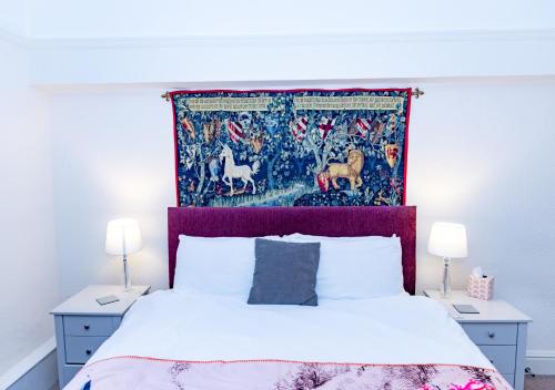 a bedroom with a bed with a tapestry above it at Raven Haven Glastonbury in Glastonbury
