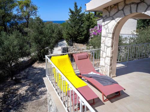 a couple of lounge chairs on a balcony at Villa Boric by the Sea in Stari Grad