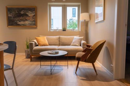 een woonkamer met een bank en een tafel bij Elegant apartment in city centre in Tromsø