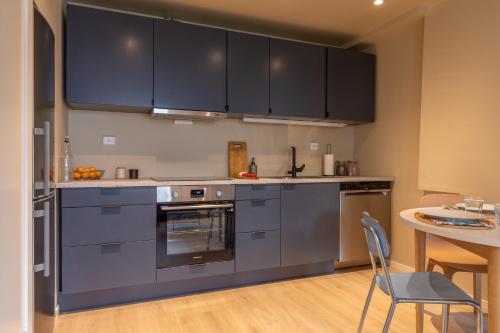 een keuken met roestvrijstalen apparatuur en een tafel bij Elegant apartment in city centre in Tromsø
