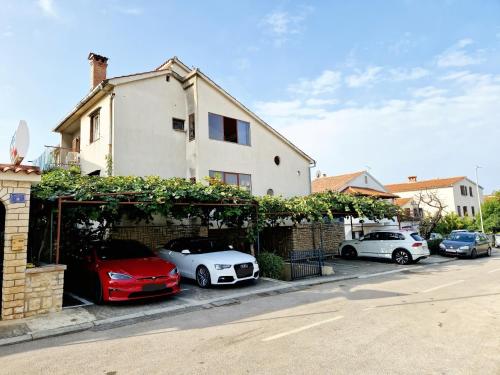 un grupo de autos estacionados frente a una casa en Villa Mihaela Porec, en Poreč