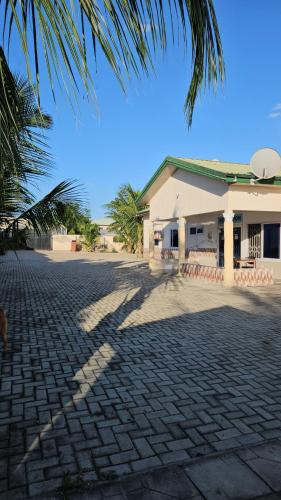 um edifício com uma palmeira em frente em My Place Guest House em Ho