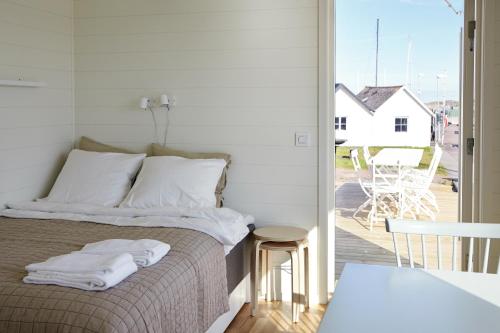 1 dormitorio con 1 cama con almohadas blancas y balcón en Kajkanten Vrångö en Vrångö