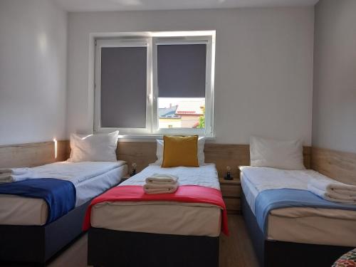 2 camas en una habitación con ventana en Jura Hotel Osiek en Olkusz