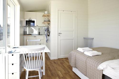 a small bedroom with a bed and a kitchen at Kajkanten Vrångö in Vrångö