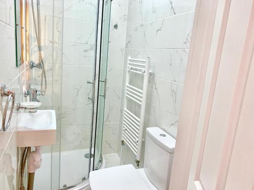 a bathroom with a shower and a toilet and a sink at London Studio Apartments Close to Station NP5 in London