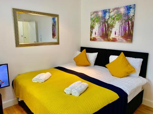 a bedroom with two beds with yellow sheets and yellow pillows at London Studio Apartments Close to Station NP5 in London
