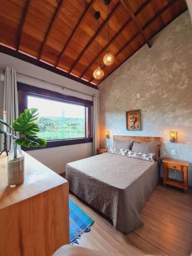 a bedroom with a bed and a large window at Casa do Lago Lapinha da Serra in Santana do Riacho