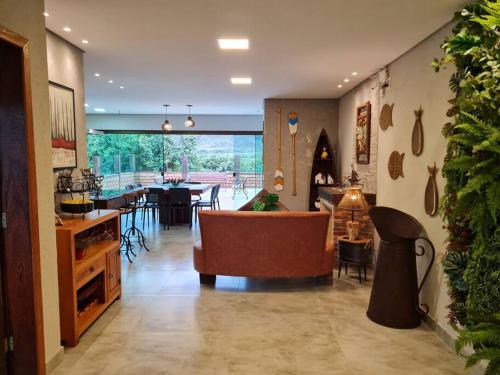 Casa do Lago Lapinha da Serra في سانتانا دي رياتشو: غرفة معيشة مع أريكة وغرفة طعام