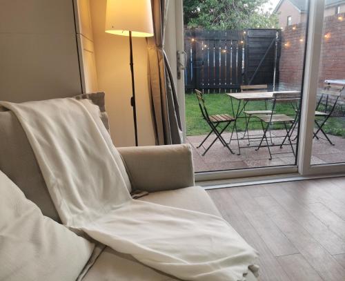 a white chair sitting in front of a sliding glass door at Peaceful house in the heart of Glasgow city, close to Queen Elizabeth Hospital and Govan subway, Free Private Parking in Glasgow