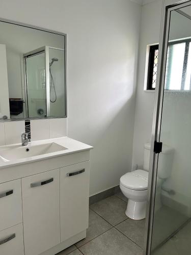 a bathroom with a toilet and a sink and a mirror at Atherton Holiday Park in Atherton