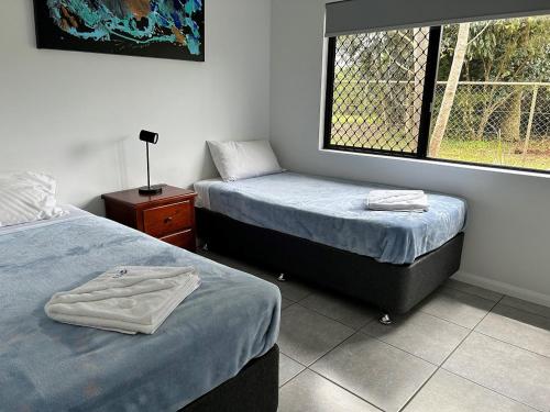 a room with two beds and a window at Atherton Holiday Park in Atherton