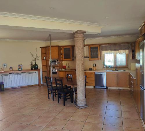 a kitchen with a table and chairs in a room at Quinta da Libelinha Alojamento Local - Mirandela in Mirandela