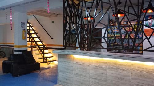 hol ze schodami, krzesłem i barem w obiekcie Hotel Marat suite w mieście Medellín