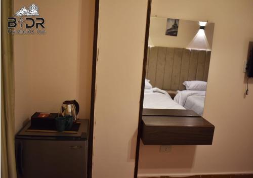 a mirror on a wall next to a bed at Badr pyramids inn in Cairo