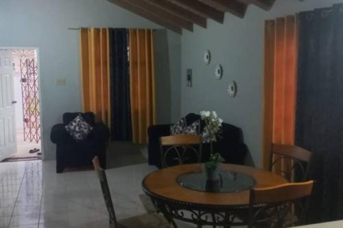 uma sala de estar com mesa e cadeiras em Oak Villa Montego Bay 2 Entire em Montego Bay