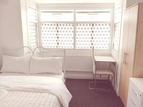 a bedroom with a bed and a window with a desk at Fresher Space Home Stay in Birmingham