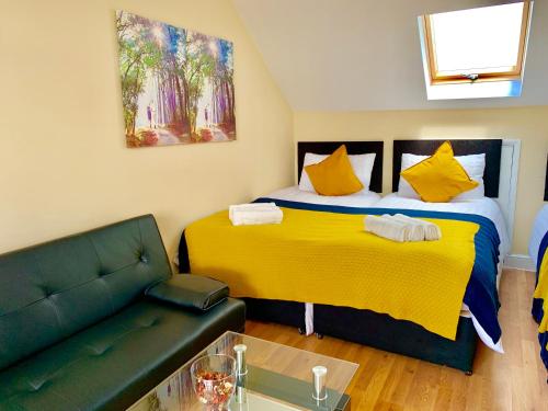 a living room with two beds and a couch at London Studio Apartments, Private Bathroom, Kitchenette, Parking, NP7 in London