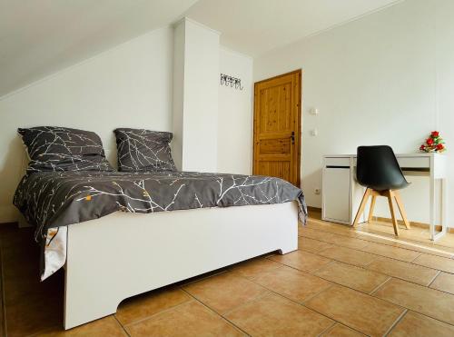 a bedroom with a bed and a desk and a chair at Grill & Garten an der Loreley mit 2 Bäder & Parkplätze in Oberwesel