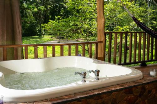 eine Badewanne mit Wasser auf einer Terrasse in der Unterkunft Brigitte's Ranch in Cahuita